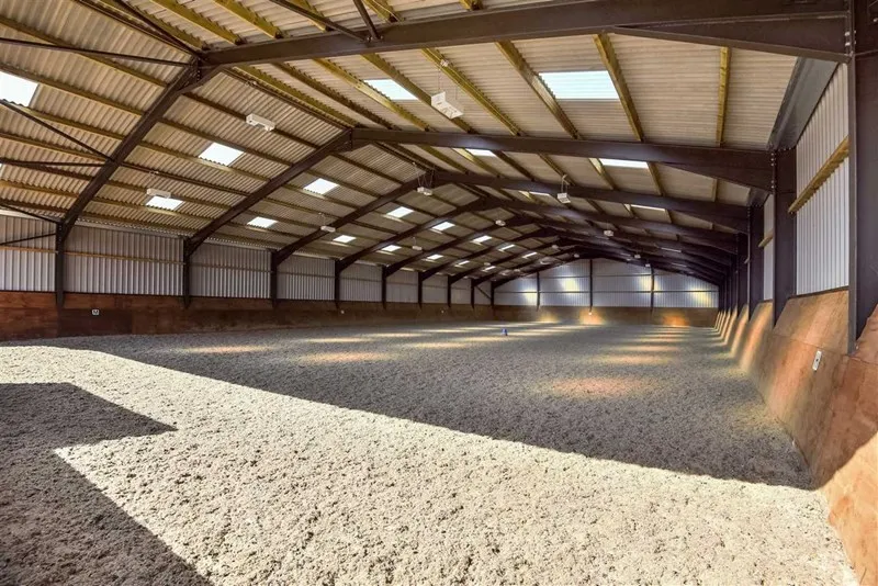 The spacious indoor arena with a fresh surface and roof lights